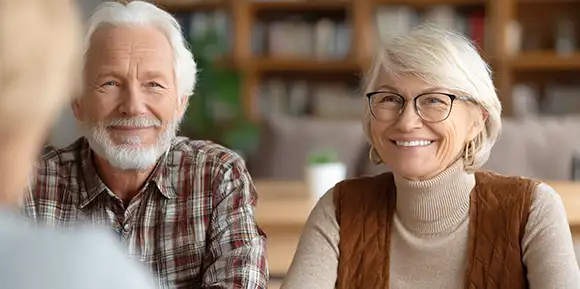 Älteres Paar lächelt während eines Gesprächs