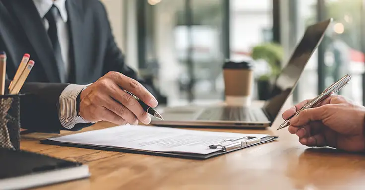 Zwei Personen besprechen Dokumente am Schreibtisch