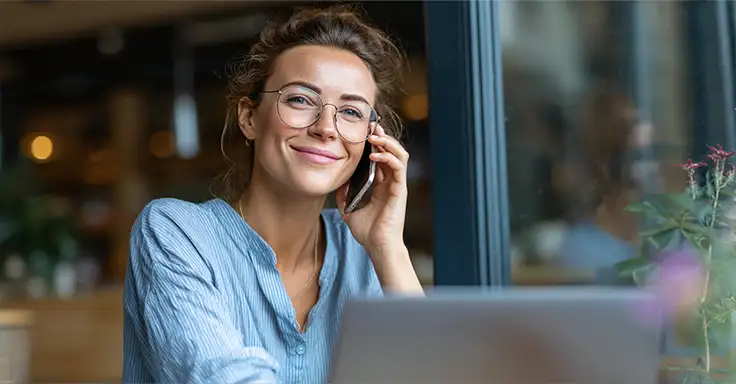 Frau telefoniert lächelnd in einem Büro