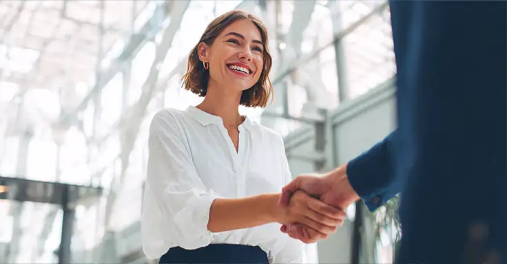Frau und Mann schütteln sich die Hände bei Immobilienbesichtigung