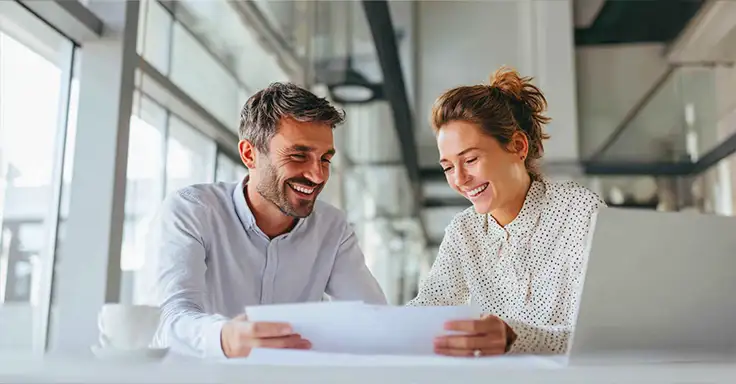 Lächelnde Personen bei der Immobilienberatung am Tisch